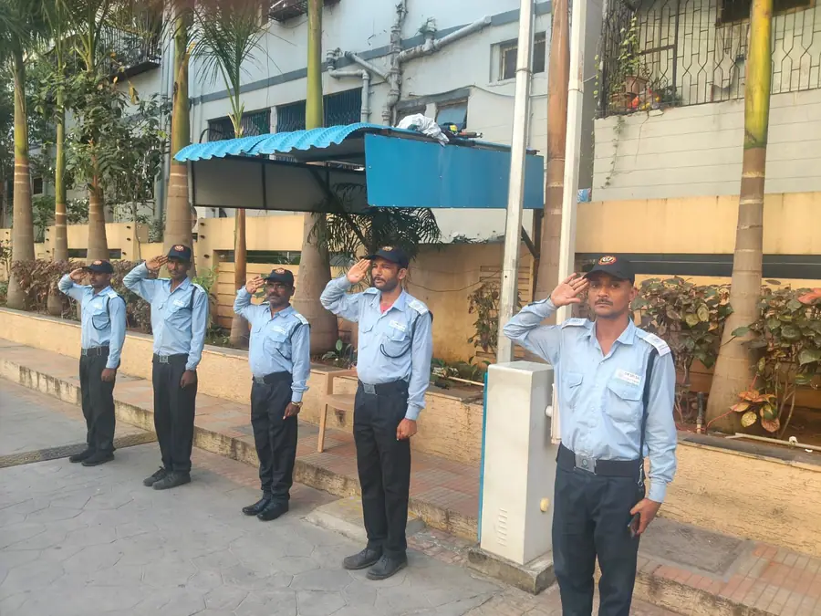 Uniformed DBR security guards saluting at a residential complex