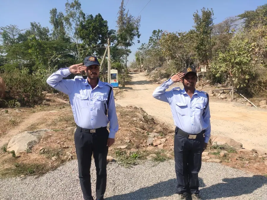 Two DBR security personnel saluting at an industrial site